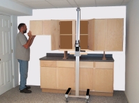 PLACE TEMPORARY CABINET SUPPORTS ON TOP OF COUNTERTOP. RAISE CABINETS TO SAME HEIGHT AS SUPPORTS. CAREFULLY LIFT AND SLIDE ONE END OF CABINET ASSEMBLY ONTO ONE SUPPORT. DO THE SAME ON THE OTHER SIDE AND REMOVE TOOL.